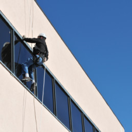 Man hanging from hundreds of feet up in the air requires a rope access structural assessment.